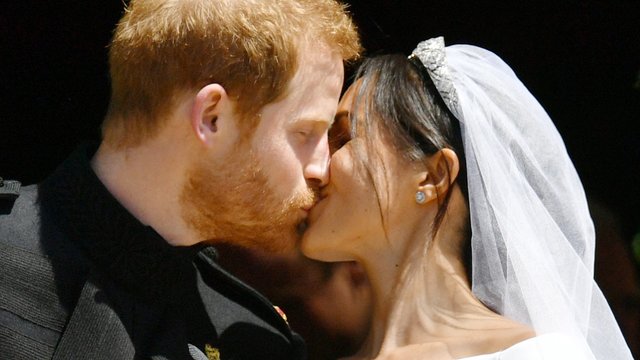 Prince Harry and Meghan Markle kiss on the steps o
