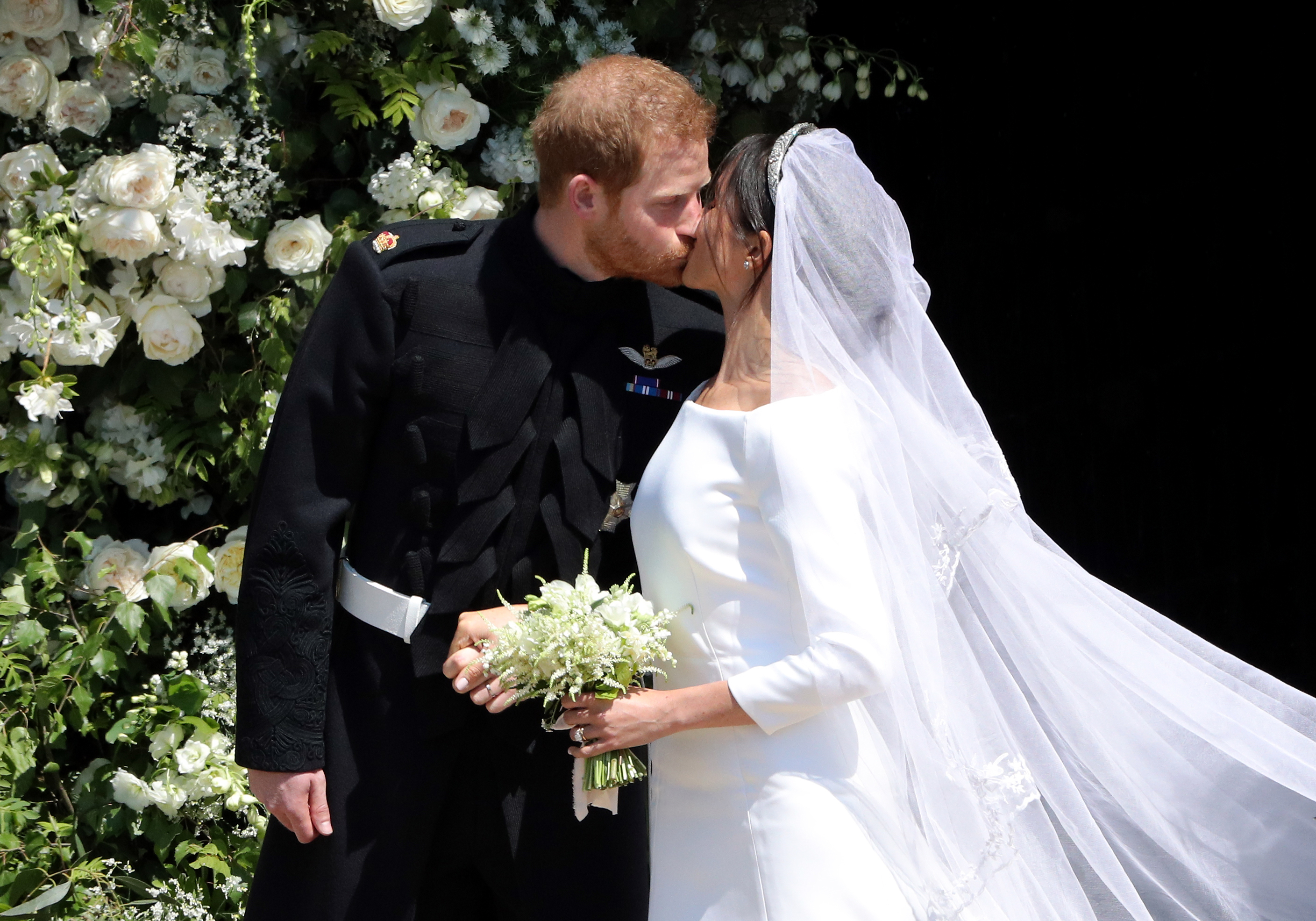 Prince Harry and Meghan Markle kiss on the steps o