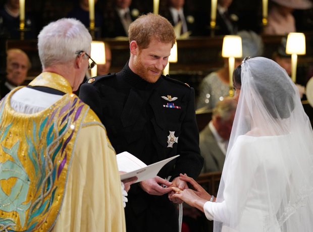 Prince Harry places the wedding ring on the finger